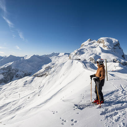 Skieur au sommet de Pra Loup avec vue sur l'Espace Lumière © Ubaye Tourisme